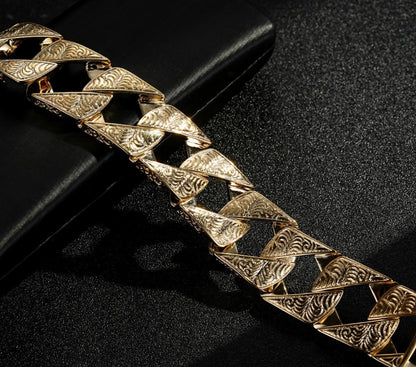 Chunky gold Cuban curb bracelet, 26mm wide, 9 inches, 130 grams, ornate design.